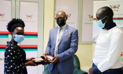 The Vice Chancellor, Prof. Barnabas Nawangwe (C) receives a pair of sandals from Miss Omega Mirembe (L) as Mr. Isaac Wanjala (R) witnesses on 28th April 2021, CTF1, Makerere University.