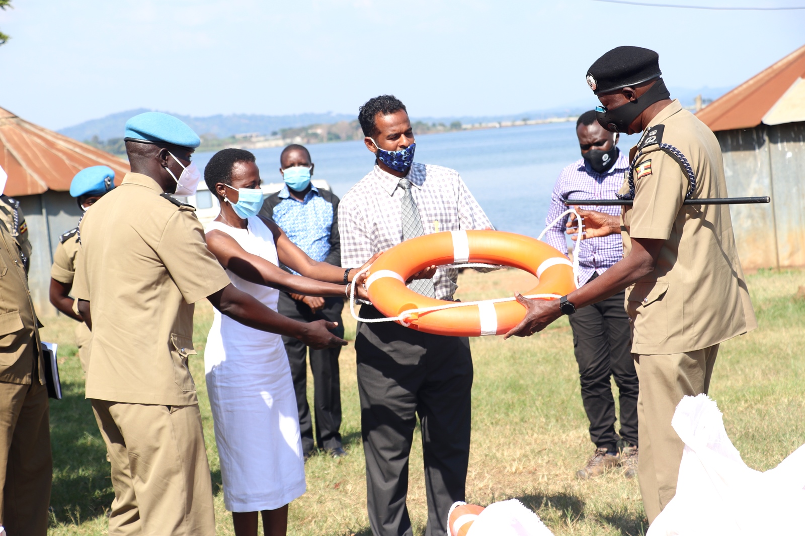 Dr. Olive Kobusingye, MakSPH Research Fellow and one of the National Drowning Strategy Researchers (2nd L) and Mr. Abdullah Ali Halage (2nd R) hand over a lifebuoy to UPF Director in charge of Operations-AIGP Edward Ochom (R) during an earlier event on 7th October 2020 at the Marine Base Headquarters, Kigo, Wakiso Uganda.