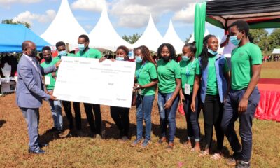 The Vice Chancellor, Prof. Barnabas Nawangwe (L) hands over a dummy cheque to the Spin Cycle Washing Machine Team at the end of the 5th Annual Entrepreneurship Students’ Expo on 5th May 2021, Rugby Grounds, Makerere University.