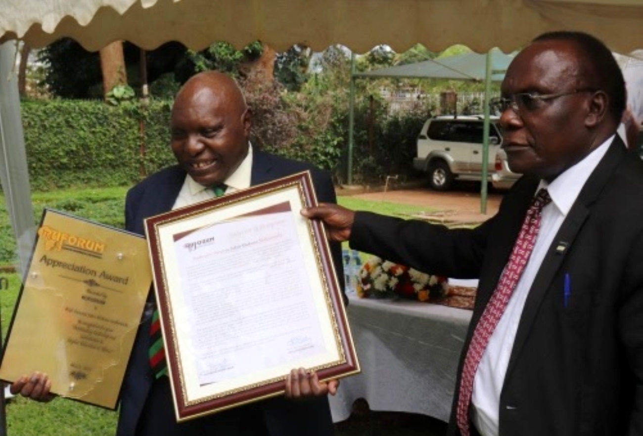 Professor Pancras John Mukasa Ssebuwufu (L) receives a plaque and citation from RUFORUM Board Member and Vice Chancellor Ndejje University-Professor Eriabu Lugujjo (Right) on 6th May 2021 at the RUFORUM Secretariat, Plot 155 Garden Hill, Makerere University Main Campus,