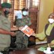 The Director-Dr. Zahara Nampewo (R) hands over a set of HURIPEC publications to Chief Political Commissar & UPDF Representative to Parliament-Maj. Gen. Henry Masiko (L) as Chief of Legal Services at the Ministry of Defence & Veteran Affairs and UPDF-Brig. Gen. Godard Busingye (C) witnesses on 15th June 2021, School of Law, Makerere University.