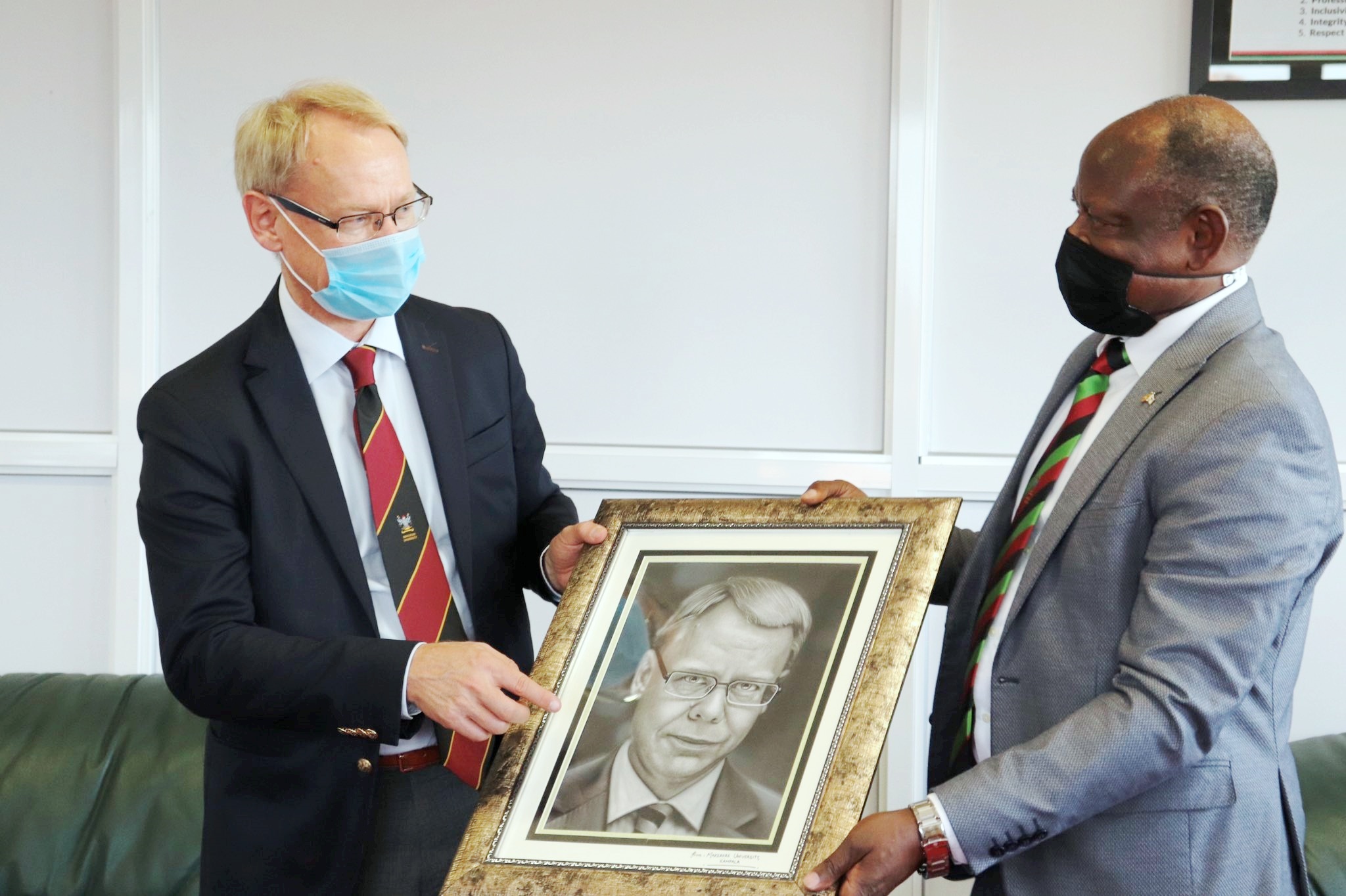 The Vice Chancellor, Prof. Barnabas Nawangwe (R) hands over a portrait to the outgoing Ambassador of Sweden to Uganda, H.E. Per Lindgärde (L) during his farewell visit on 21st June 2021, CTF1, Makerere University.