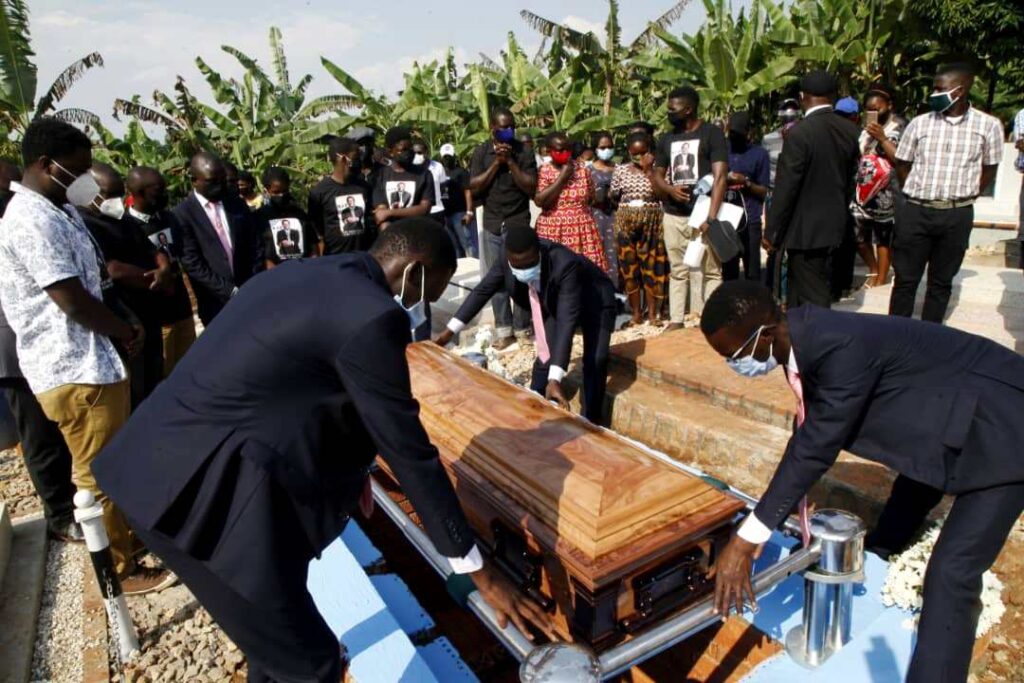 The pallbearers lower Prof. Banadda's remains into the grave.
