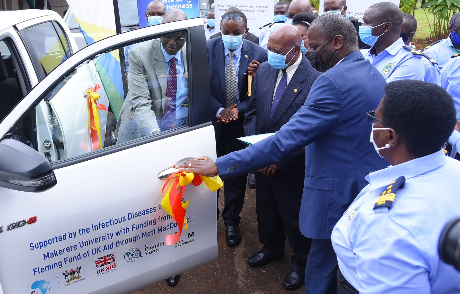 Hon. Bright Rwamirama (L) commissions the car handed over by IDI Executive Director-Dr. Andrew Kambugu (L) to the Dairy Development Authority to the support AMR programme on 5th May 2021, DDA Headquarters, Kampala.