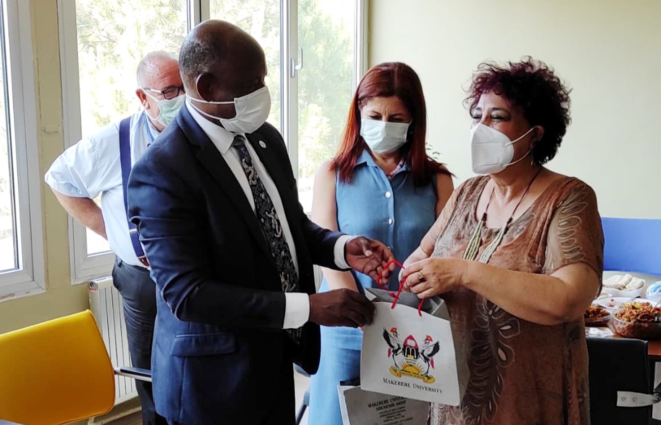 The Vice Chancellor, Prof. Barnabas Nawangwe (L) hands over an assortment of Makerere University souvenirs to one of the staff during the benchmarking visit to Cukurova University, Adana, Turkey on 5th July 2021.