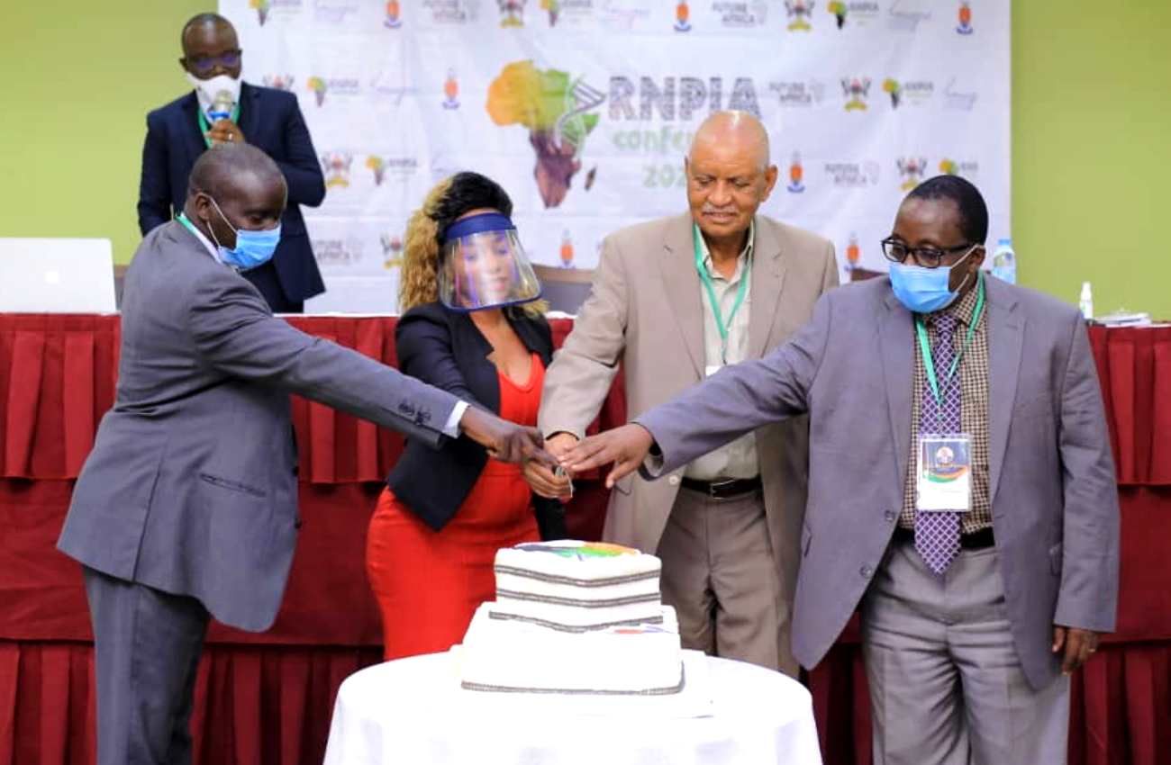 Hon. Prof. Mondo Kagonyera (2nd R) is joined by L-R: Prof. Paul Waako, Dr. Alice Nabatanzi and Prof. John David Kabasa to cut cake during the 1st RNPIA Conference Opening Ceremony, 5th July 2021, Imperial Royale Hotel, Kampala Uganda.