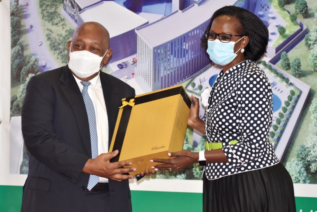 The Chairperson of Council, Mrs. Lorna Magara (R) hands over a token of appreciation to Chairman of the Inaugural Board of Mak Holdings, Mr. Charles Mbire during the ceremony on 9th September 2021.