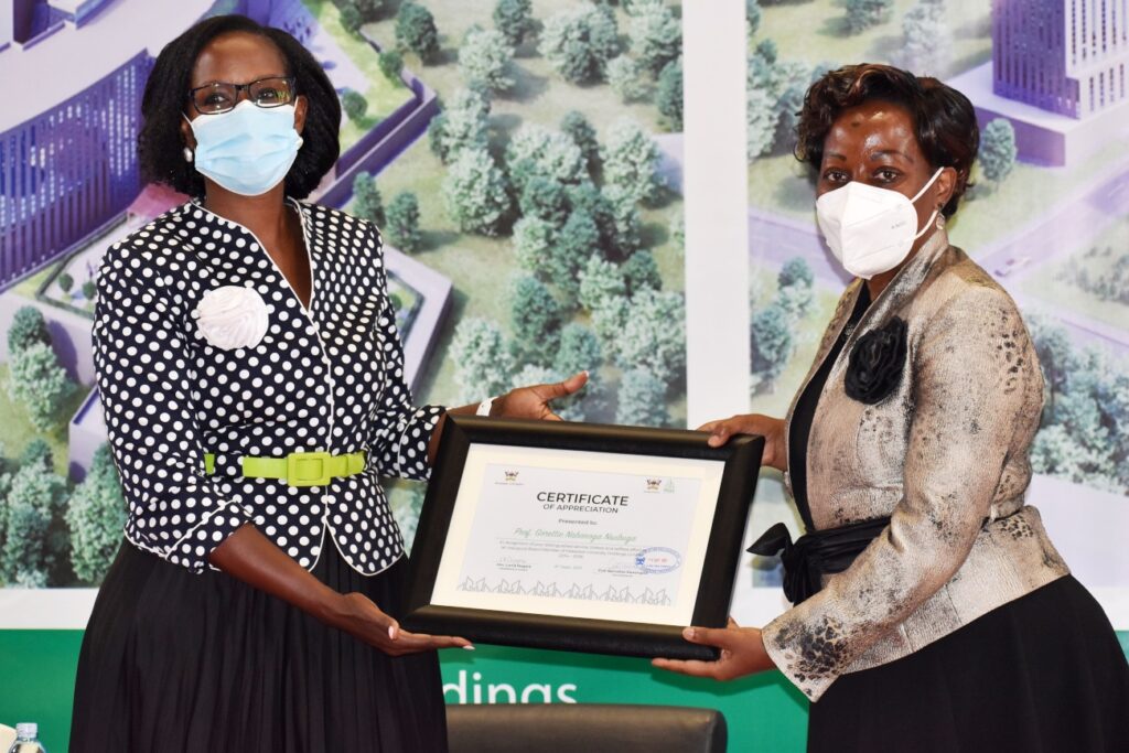 The Chairperson of Council, Mrs. Lorna Magara (L) presents a certificate of appreciation to Dr. Gorettie Nsubuga Nabanoga (R), one of the Inaugural Board Members of Mak Holdings.