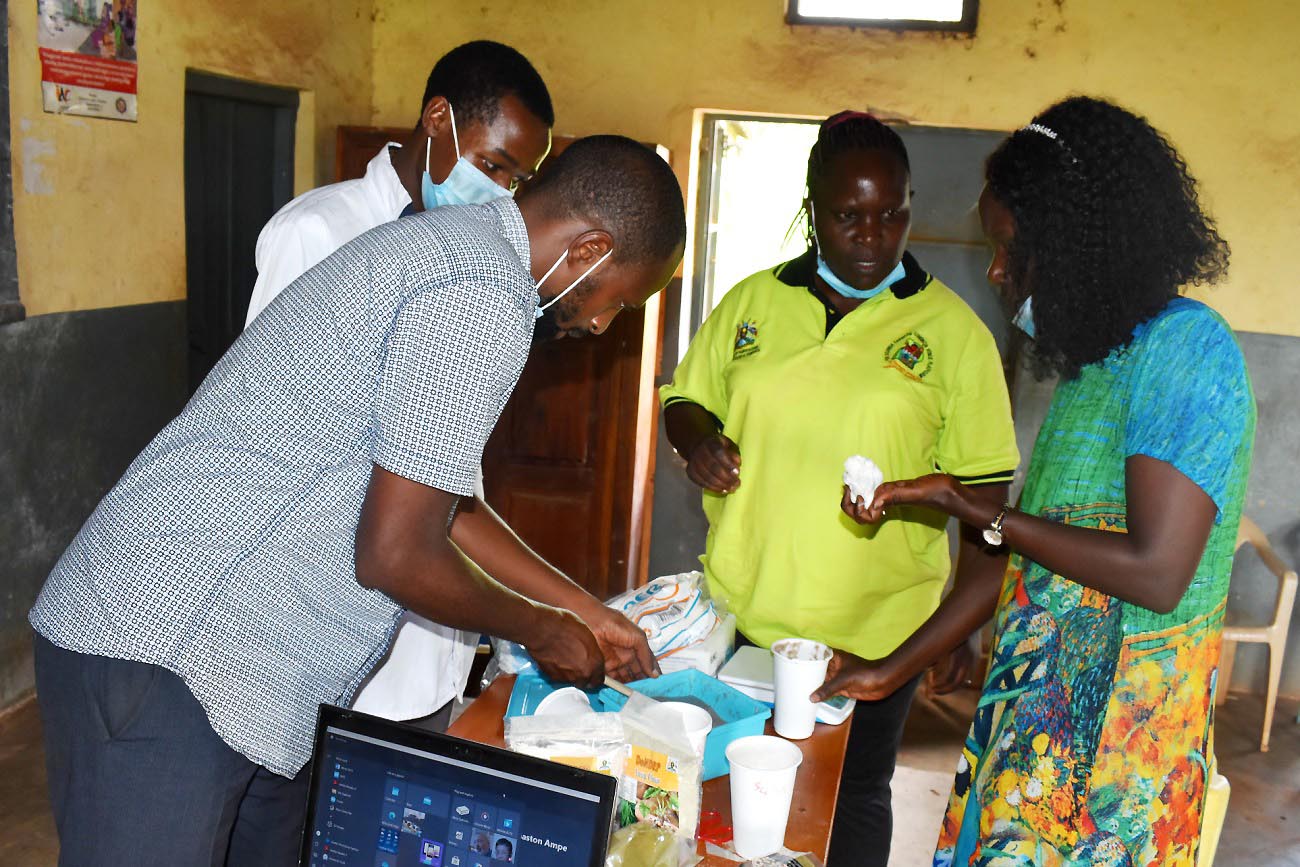 The Research Team from Right to Left: PI-Dr. Agnes Nabubuya, Dr. Immaculate Nakalembe, Undergrad student-Mr. Mwaka and Masters student-Mr. Paddy Ainebyona prepare some of the products for tasting by participants on 9th October 2021, Kigorobya sub-County, Hoima District.