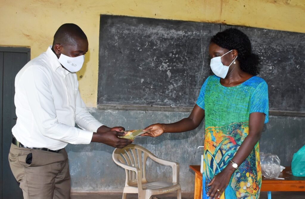 PI-Dr. Agnes Nabubuya (R) hands over one of the products to Kigorobya sub-County Chief Mwesigwa Rwamukaga Steven (L) during the research dissemination.