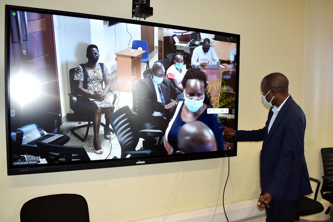 Assoc. Prof. Eria Hisali commissions the IT equipment by writing on the smart board in the PIM CoE Conference Room, 4th October 2021, CTF2, Makerere University.