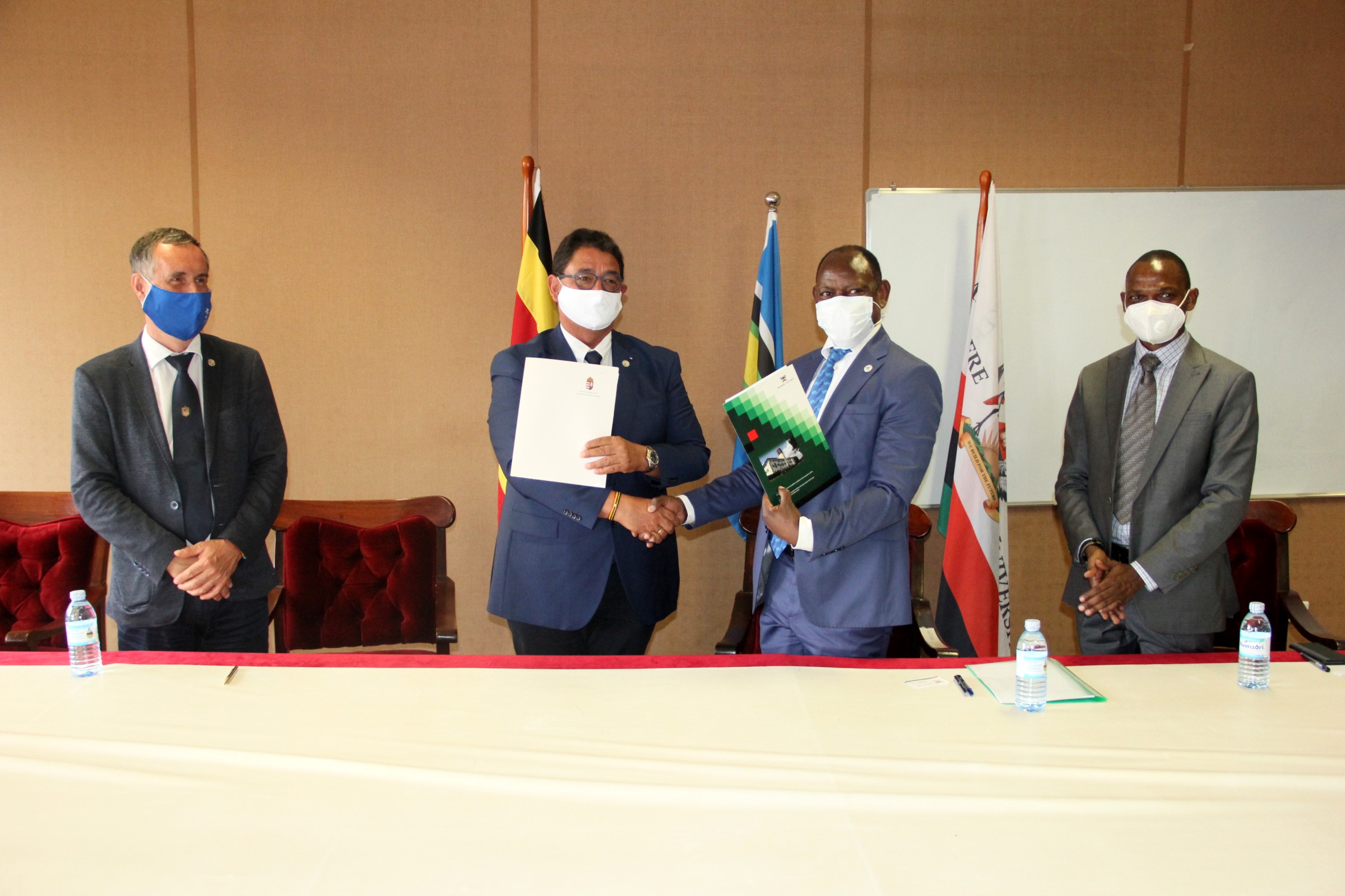 The Vice Chancellor-Prof. Barnabas Nawangwe (2nd R) and Semmelweis University Rector-Prof. Béla Merkely (2nd L) exchange the signed MoU as DVCAA-Dr. Umar Kakumba (R) and Semmelweis University Vice Rector- Prof. Attila Szabó (L) witness on 25th October 2021, CTF1, Makerere University.