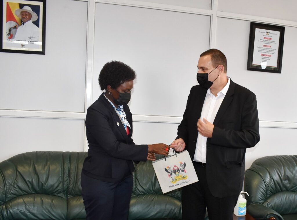 The Acting Vice Chancellor and DVCFA-Assoc. Prof. Josephine Nabukenya (L) hands over a gift to Mr. Yaron Tamir (R) during the courtesy call on 13th October 2021, CTF1, Makerere University. 