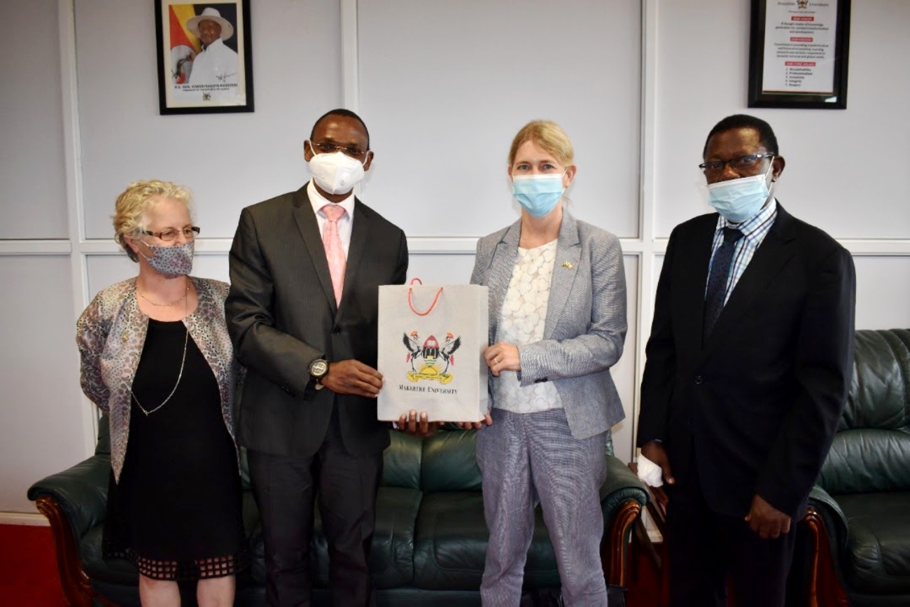 The Acting Vice Chancellor and Deputy Vice Chancellor (Academic Affairs)-Dr. Umar Kakumba (2nd L) presents an assortment of souvenirs to Ambassador Maria Håkansson (2nd R) as Prof. Buyinza Mukadasi (R) and Dr. Gity Behravan (L) witness on 30th September 2021, CTF1, Makerere University.