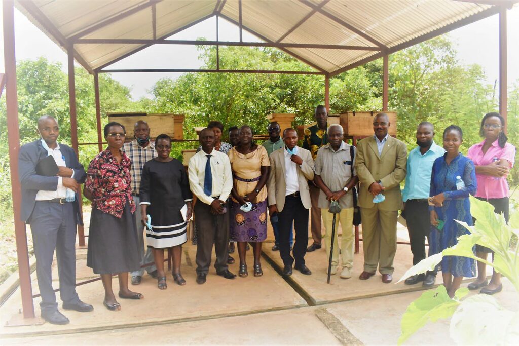 The researchers together with former and current members of staff pose for a photo with the Commissioner Entomology, Mr Lawrence Tusimomuhangi at the Meliponary at NaLIRRI.