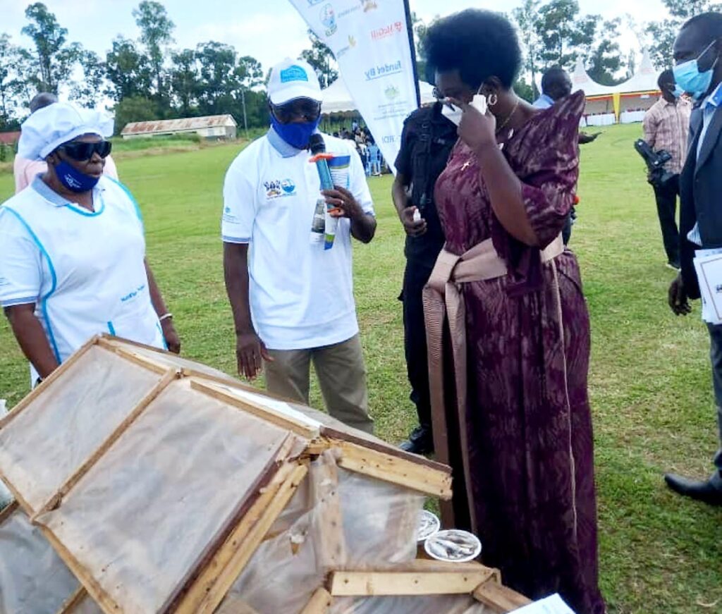 Dr. Jackson Efitre (2nd L) explaining to the Minister how the solar tent drier works.