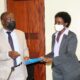 Outgoing Ag. DVCFA-Dr. Josephine Nabukenya (R) presents a copy of her handover report to incoming Ag. DVCFA-Prof. Henry Alinaitwe (L) during the ceremony on 24th November 2021, CTF1, Makerere University.