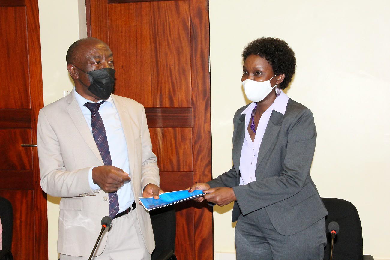 Outgoing Ag. DVCFA-Dr. Josephine Nabukenya (R) presents a copy of her handover report to incoming Ag. DVCFA-Prof. Henry Alinaitwe (L) during the ceremony on 24th November 2021, CTF1, Makerere University.