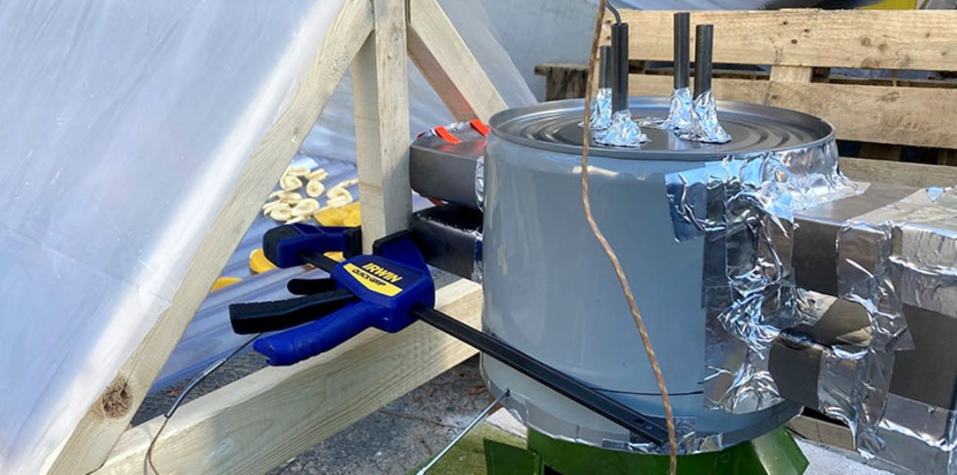 Drying jackfruit, bananas, and mangoes in our solar dryer using the heat exchanger with a double-pass on the Makaa cookstove. Photo: MIT D-Lab