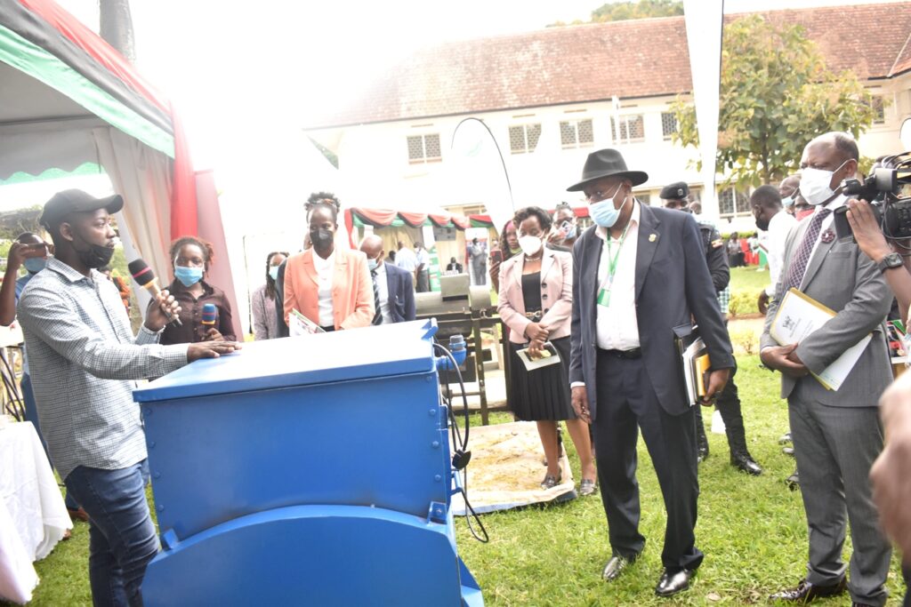 A Masters student (L) showcasing a machine he invented to aid soap processing.