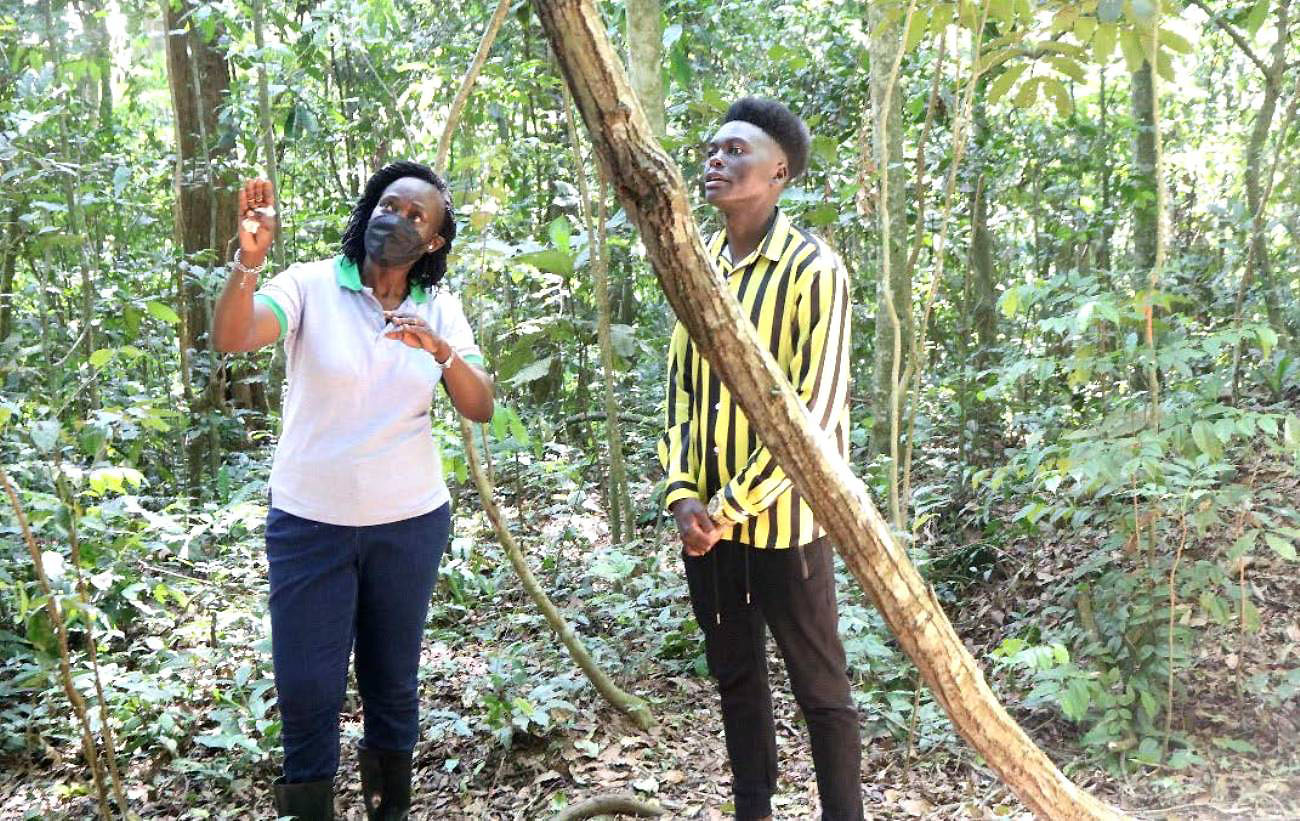 Assoc. Prof Angelina Kakooza-Mwesige (L) engages with the caretaker and guide of Zika forest. Photo credit: THRiVE