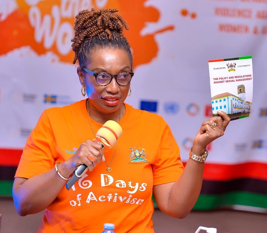 Ms. Adekemi Ndieli gestures with a copy of the Makerere University Policy and Regulations Against Sexual Harassment 2018 which were handed out to every participant at the dialogue. 