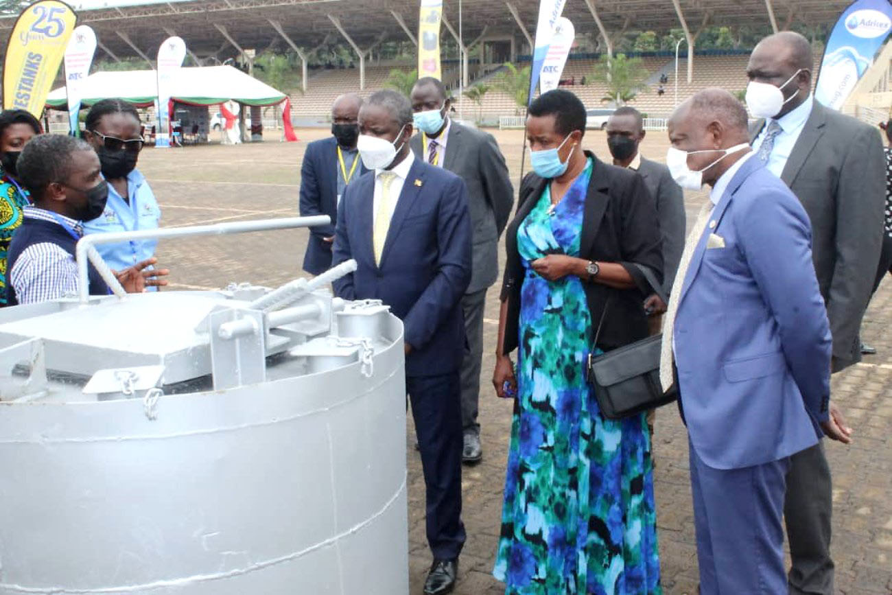 The Government Chief Whip, Hon. Thomas Tayebwa (3rd R), State Minister for Water, Hon. Aisha Sekindi (2nd R), Vice Chancellor, Prof. Barnabas Nawangwe (R) and other officials listen to an exhibitor at the Appropriate Technology Exhibition on 26th November 2021 at the Kololo Independence Grounds.