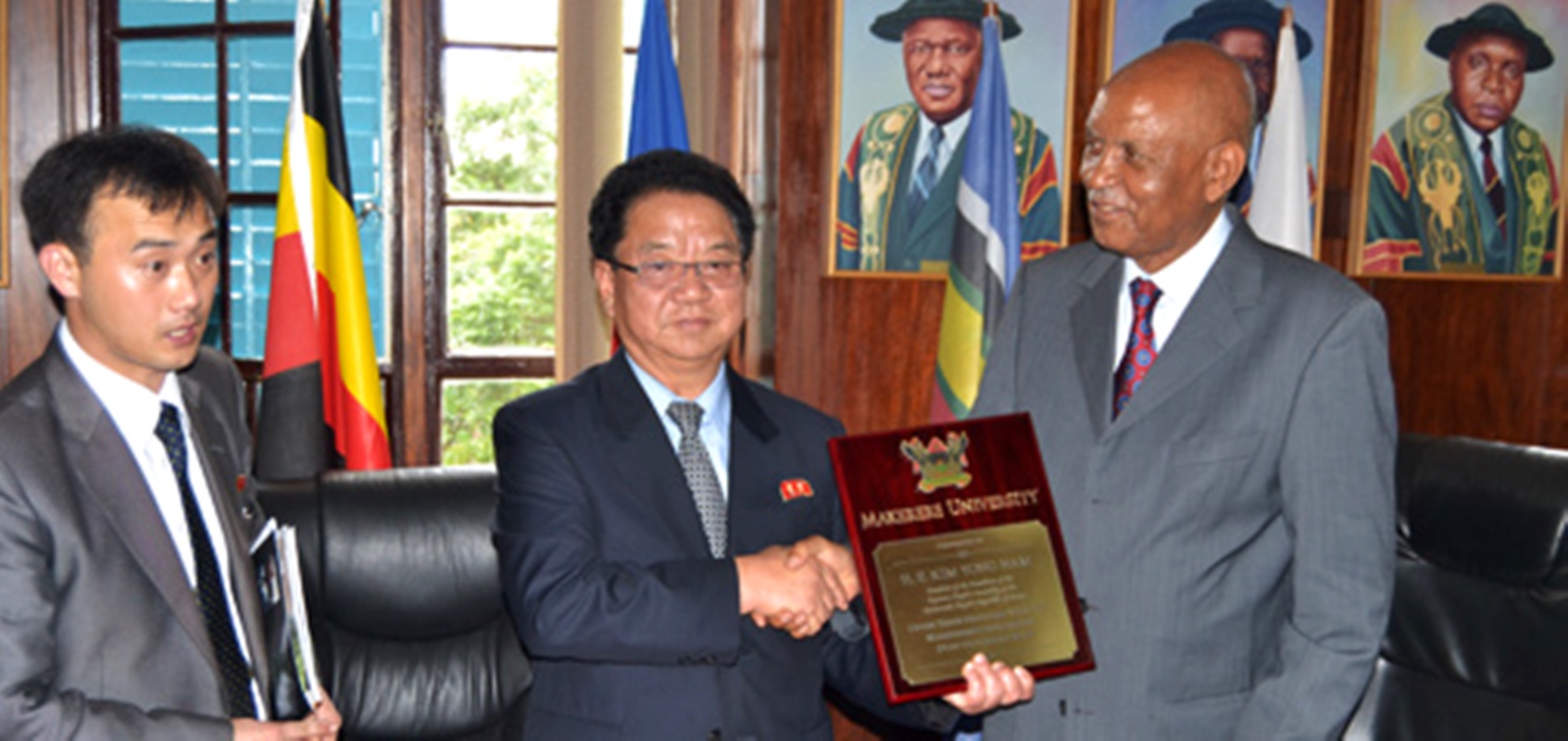 Hon. Kang Ha Kuk, Minister of Health of DPRK (C) receiving a plaque from The Chancellor, Makerere University Prof. George Mondo Kagonyera (R) during the visit on 31st October 2014.