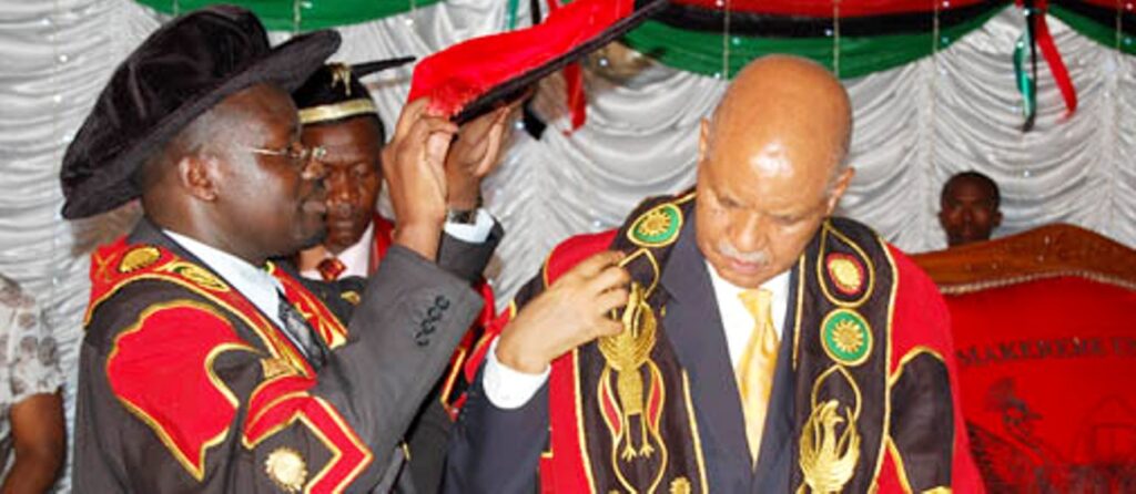 Vice Chancellor, Prof. Venansius Baryamureeba (L) adorns Prof. Mondo Kagonyera with a cap after his installation as Chancellor, Makerere University. 