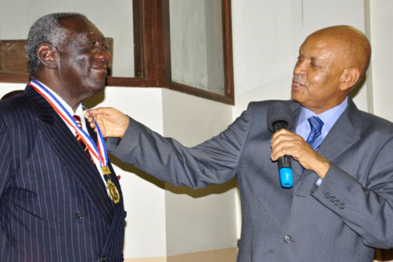 The Chancellor,Prof. Mondo Kagonyera (R) decorates H.E. John Agyekum Kufuor (L) with a medallion in appreciation of his public lecture on 2nd August 2013, Makerere University, Kampala Uganda.