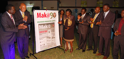 Hon. Jessica Alupo unveils the Mak@90 Magazine as dignitaries applaud. 
