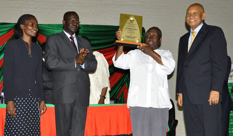 Dr. Okello Ogwang (2nd L) and Dr. Susan Kiguli (L) after presenting the plaque to Prof. Ngugi wa Thiong’o (2nd R) as the Chancellor Prof. Mondo Kagonyera (R) beams. 