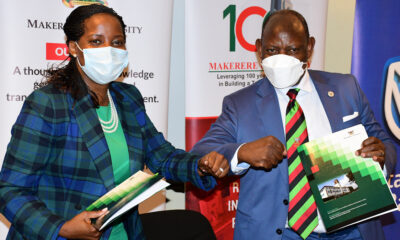 The Vice Chancellor Prof. Barnabas Nawangwe (R) and Stanbic Bank Chief Executive Officer Ms Anne Juuko (L) bump elbows after signing the Laptop hire purchase scheme Memorandum of Understanding at Central Teaching Facility 1(CTF1)-Makerere University on 15th February 2022.