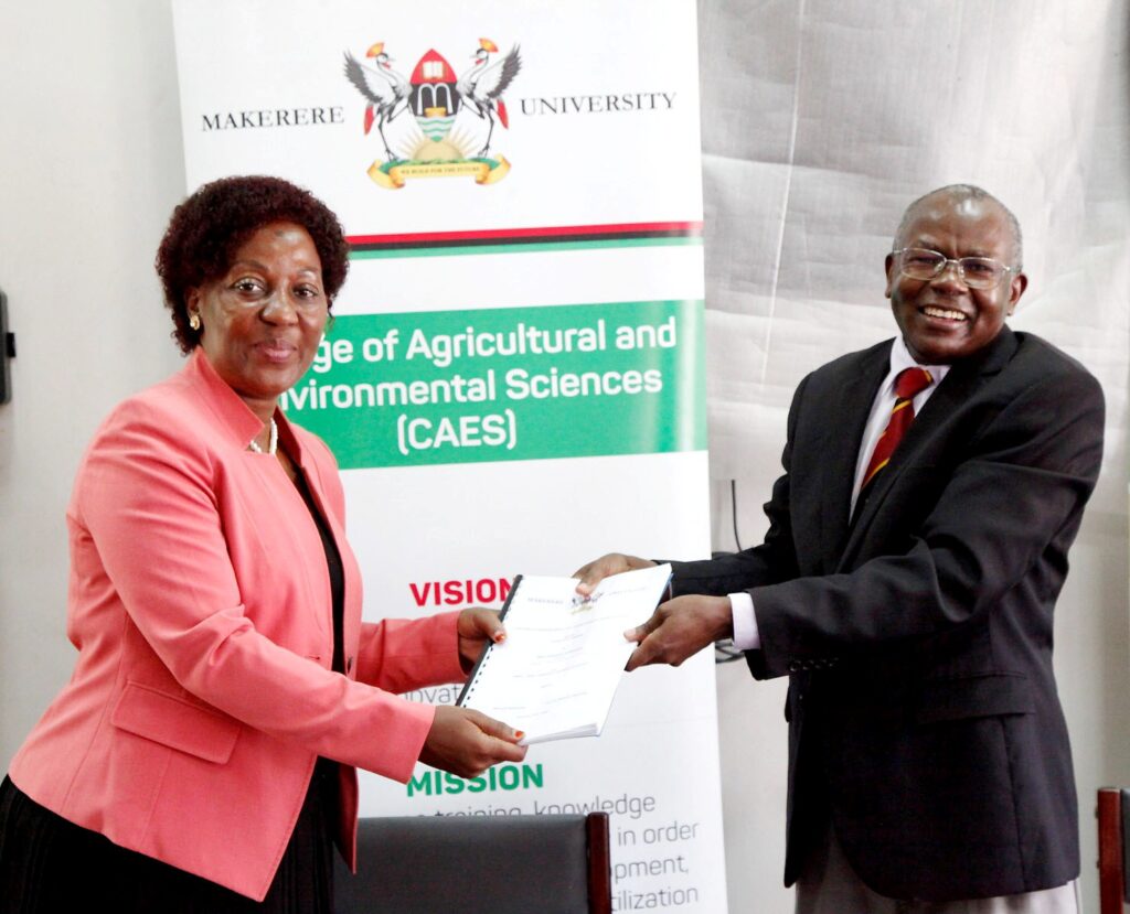 Prof. Bernard Bashaasha (R) presents a copy of his handover report to Dr. Gorettie N. Nabanoga (L).