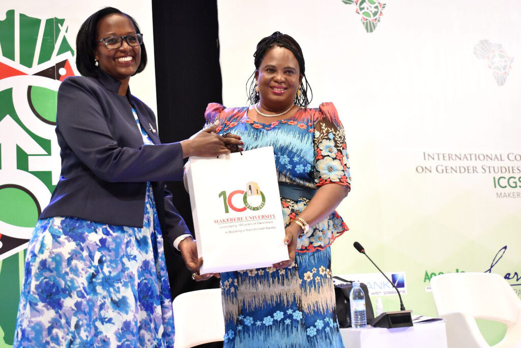 The Chairperson of Council, Mrs. Lorna Magara (L) presents an assortment of Makerere University Souvenirs to Hon. Betty Amongi Akena at the ICGSA-2022 Closing ceremony.