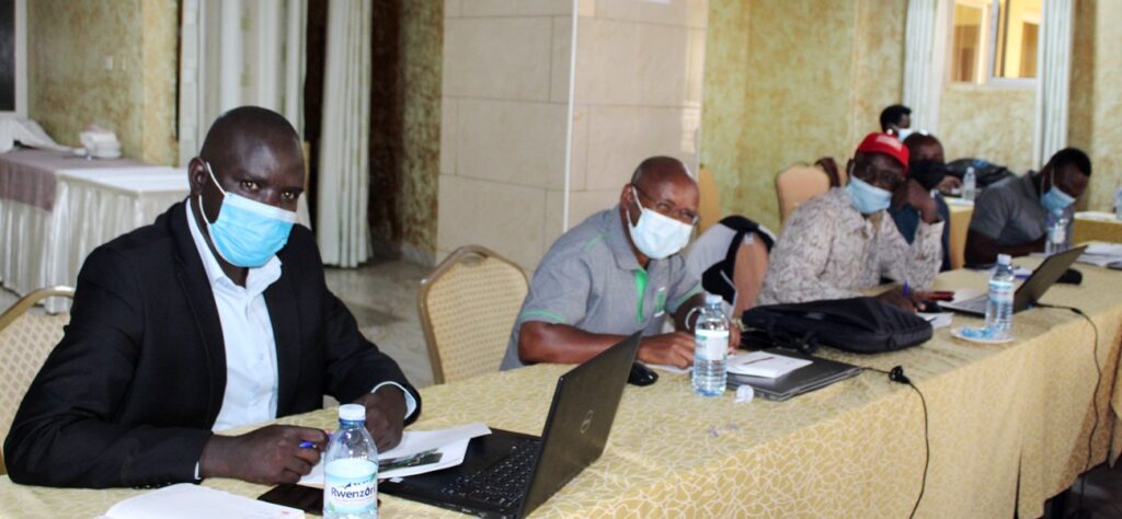Epiaka William from the National Planning Authority (L) and other participants  during the strategic plan meeting.