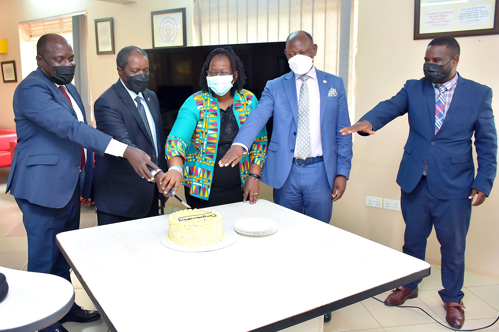 The Vice Chancellor, Prof. Barnabas Nawangwe (2nd R) joins Head GAMSU-Prof. Grace Bantebya (C), Head Mak-RIF-Prof. Fred Masagazi Masaazi (L), Outgoing Head GAMSU & Mak-RIF-Prof. William Bazeyo (2nd L) and Dr. Robert Wamala-DRGT (R) to cut cake at the Induction Ceremony on 8th February 2022 at the RAN Offices in Kololo.
