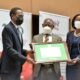 The Attorney General, Hon. Kiryowa Kiwanuka (L) receives his Eminent Service Award from Council Chairperson, Mrs. Lorna Magara (R) and Vice Chancellor, Prof. Barnabas Nawangwe (C).