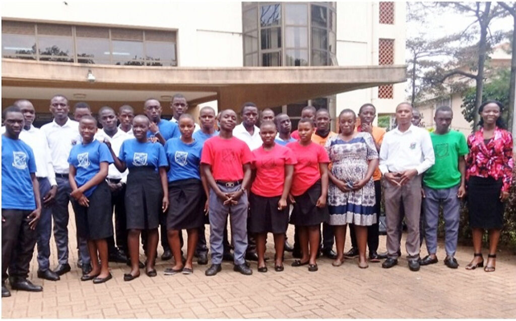 The Principal PRO, Makerere University-Ms. Ritah Namisango (Right) with Buzzibwera SS Career and Guidance teacher Ms. Rachel Nakazinga (4th R) and her students outside the Main University Library during their visit. (Photo by Alex Mugalu)