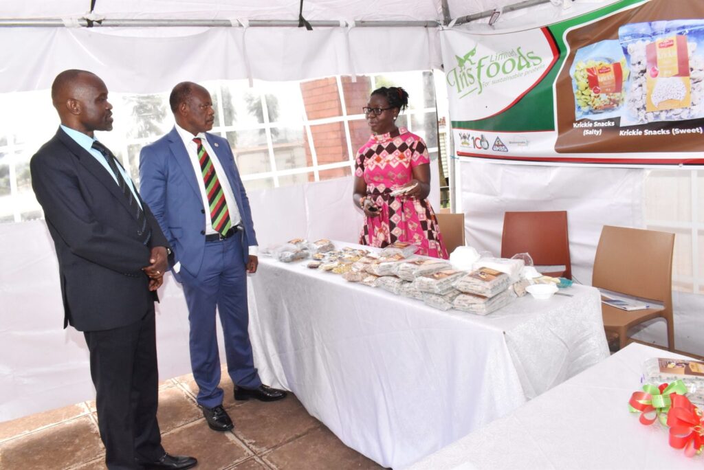 The Vice Chancellor Prof. Barnabas Nawangwe (C) and the Executive-Director of UNBS Mr.-David-Livingstone Ebiru (L) getting information on the products from the Project PI Dr Dorothy-Nakimbugwe (R).