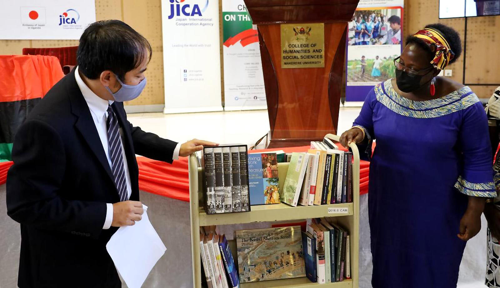 Senior Representative of JICA Mr. Fukuhara Ichiro (Left) presents the book donation to the Principal CHUSS, Associate Prof. Josephine Ahikire (Right) on 25th March 2022 at a colourful ceremony held in the CTF2 Auditorium.
