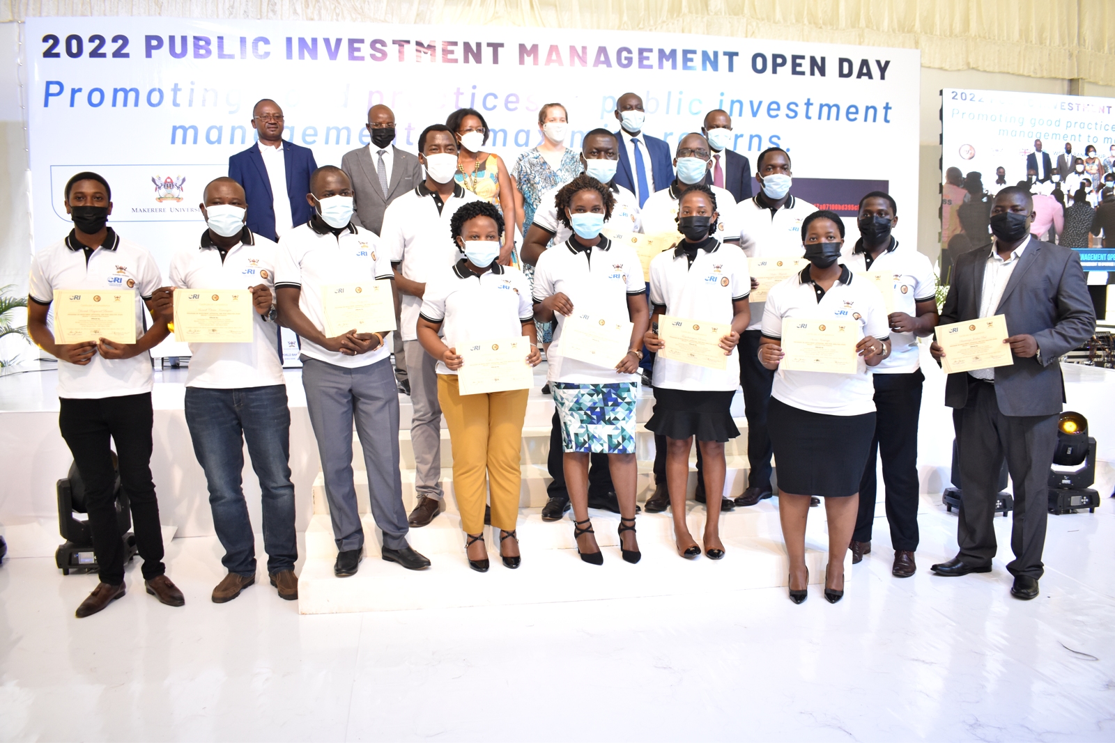 Rear R-L: Principal CoBAMS-Prof. Eria Hisali, Mr. Ashaba Hannington-MoFPED, Jordan Martindale-FCDO, Ms. Mukami Kariuki-World Bank Country Manager Uganda, Prof. Edward Bbaale-PI PIM CoE and Dr. Willy Kagarura-Manager PIM CoE with some of the trainees who received certificates in Financial and Risk Analysis on 10th March 2022, Freedom Square, Makerere University.