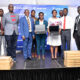 Vice Chancellor-Prof. Barnabas Nawangwe (3rd L), Guild President-H.E. Shamim Nambassa (C), Stanbic Bank Uganda Chief Executive-Ms Anne Juuko (4th R), Sam Mwogeza-Stanbic (R), Simon Nkuyahaga-HGZ Technologies (2nd L), Rt. Hon. Gatuya Mucyo (L) and other officials after the launch of the Laptop Loan Scheme on 10th Mar 2022.