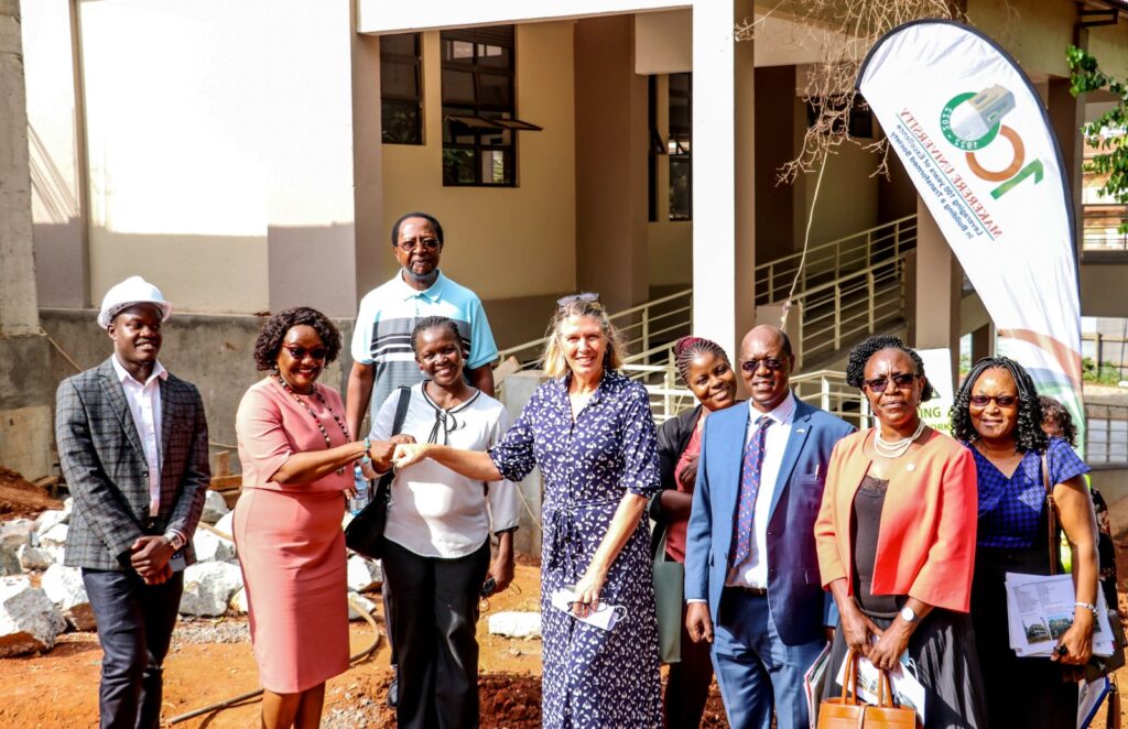 H.E. Dr. Karin Boven bunches fists with Prof. Rhoda Wanyenze (2nd L) during a tour of the MakSPH's New Home currently under construction. 