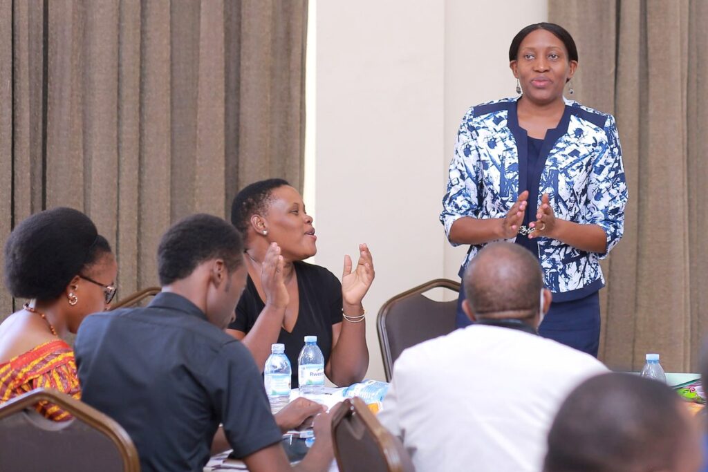 Dr. Cathy Mbidde (standing) and Dr. Sarah Bimbona (clapping) celebrate their students