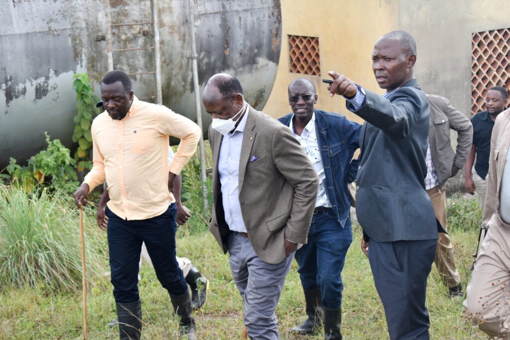 The Farm Manager, Dr. Mathias Wasswa (R) explains the water supply system at the farm.