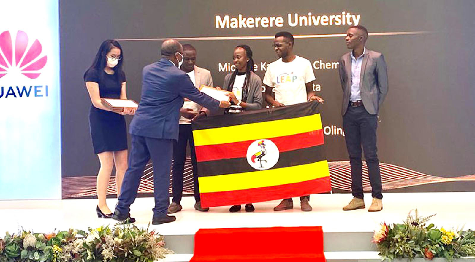 The State Minister for Higher Education, Hon. Dr. John Chrysostom Muyingo (2nd L) presents awards to the winning team; Rutanana Arnold, Nakyanzi Catherine and Nsengiyumva Wiberforce at the award ceremony in South Africa. (Courtesy Photo)