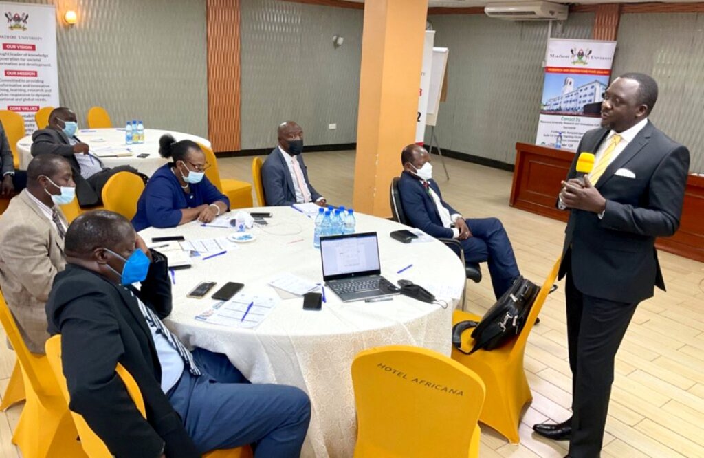 The University Secretary-Mr. Yusuf Kiranda (standing) reacts to the presentation as L-R: University Bursar-Mr. Evarist Bainomugisha, Principal CoCIS-Prof. Tonny Oyana, University Librarian-Associate Prof. Helen Byamugisha, Ag. DVCFA-Prof. Henry Alinaitwe and the Vice Chancellor-Prof. Barnabas Nawangwe listen. 