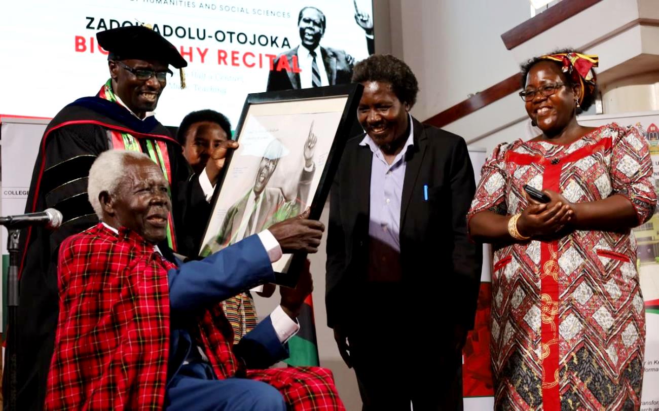 R-L: Assoc. Prof. Josephine Ahikire, Assoc. Prof. Patrick Mangeni, Assoc. Prof. Mercy Ntangaare and Dr. Milton Wabyona with a beaming Mr. Zadok Adolu-Otojoka (seated) during the presentation of his portrait on 31st March 2022, St. Francis Chapel, Makerere University.