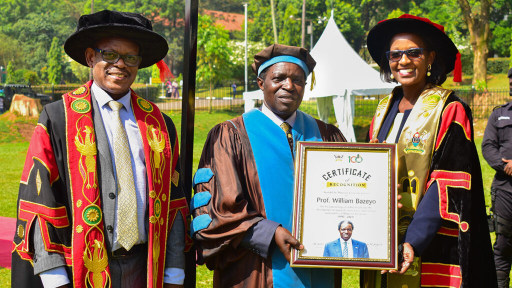 Mak Council Chairperson Mrs. Lorna Magara (R) hands over a framed certificate to Prof. William Bazeyo (C) in appreciation of his service to Makerere University, during the First Session of the 72nd Graduation on Monday 23rd May 2022 at the Freedom Square. Left is the Vice Chancellor Prof. Barnabas Nawagwe.